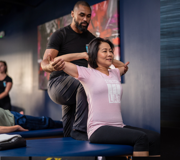 StretchLab instructor assisting person with stretch